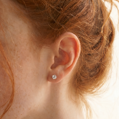 Close-up of a person wearing a diamond earring 