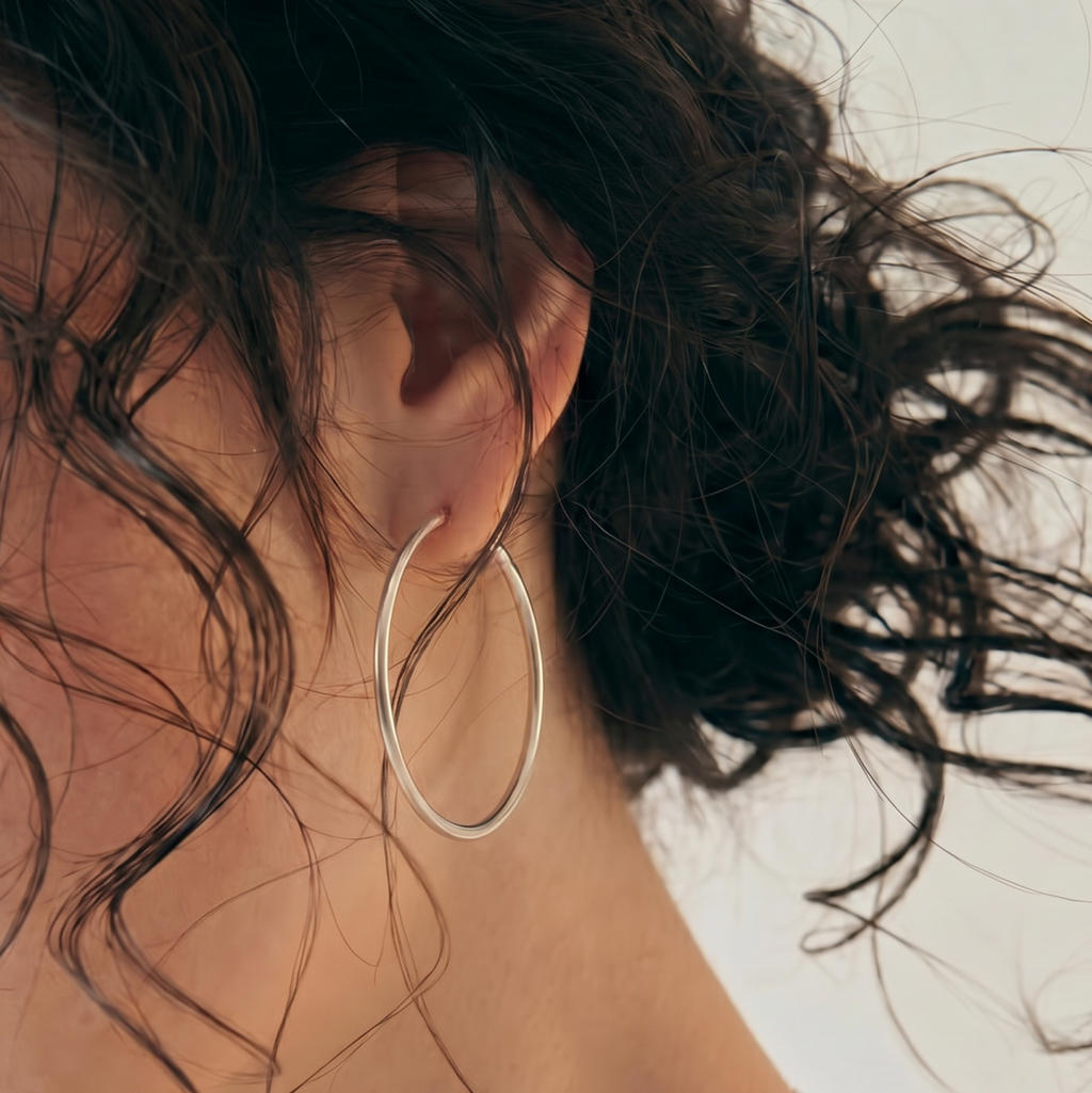 Close-up of a woman wearing Silver hoop earrings