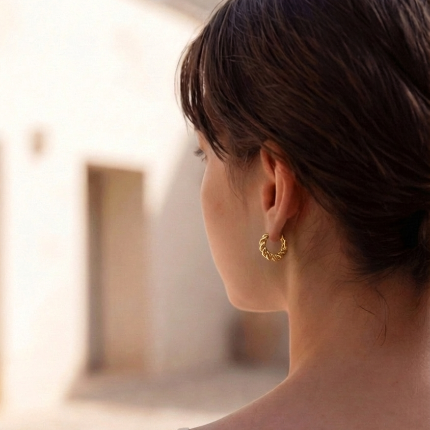 Woman wearing a gold earring with a blurred background