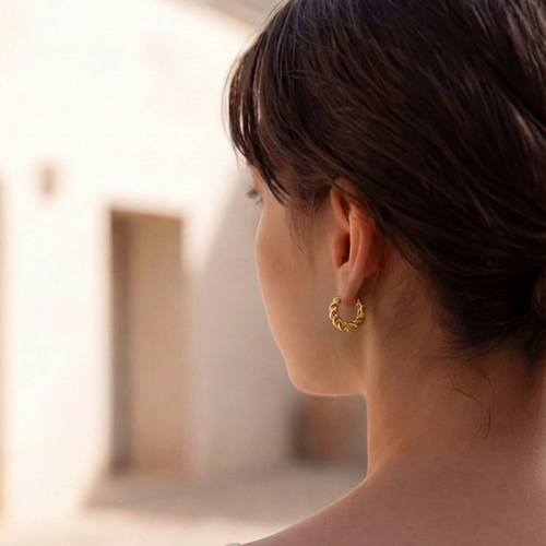 Woman wearing a gold earring with a blurred background