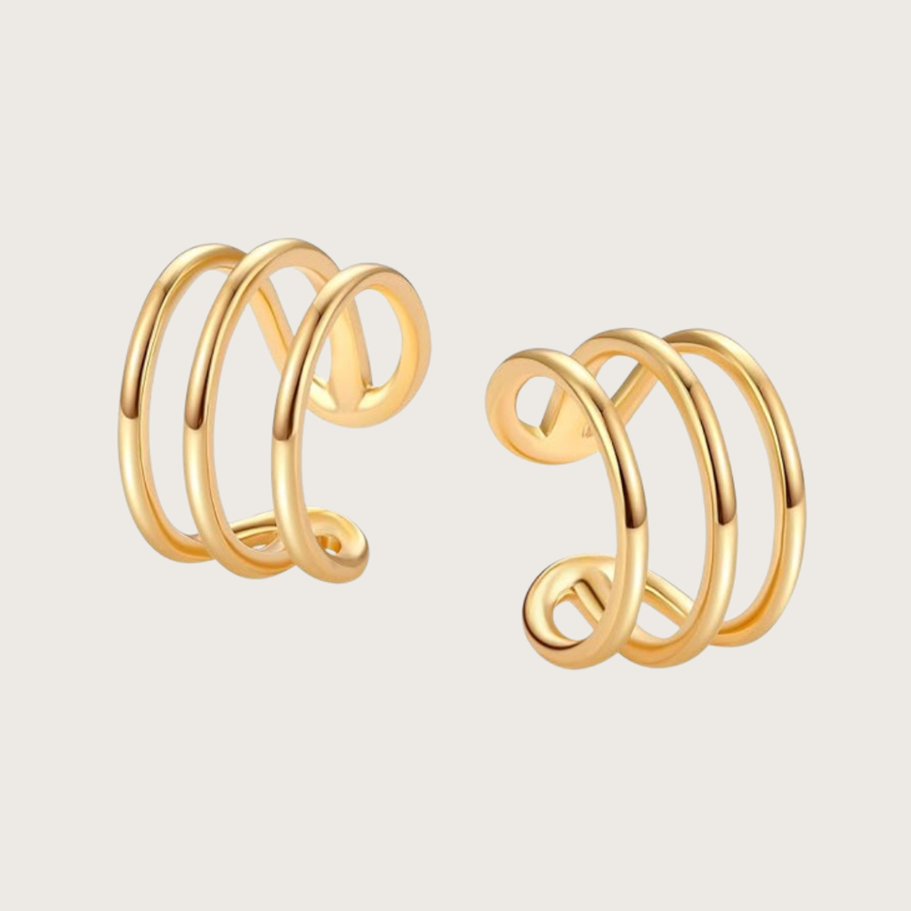 Pair of gold spiral earrings on a light beige background